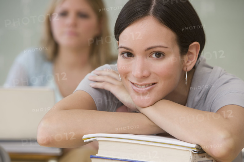 Woman with chin on hand in classroom.