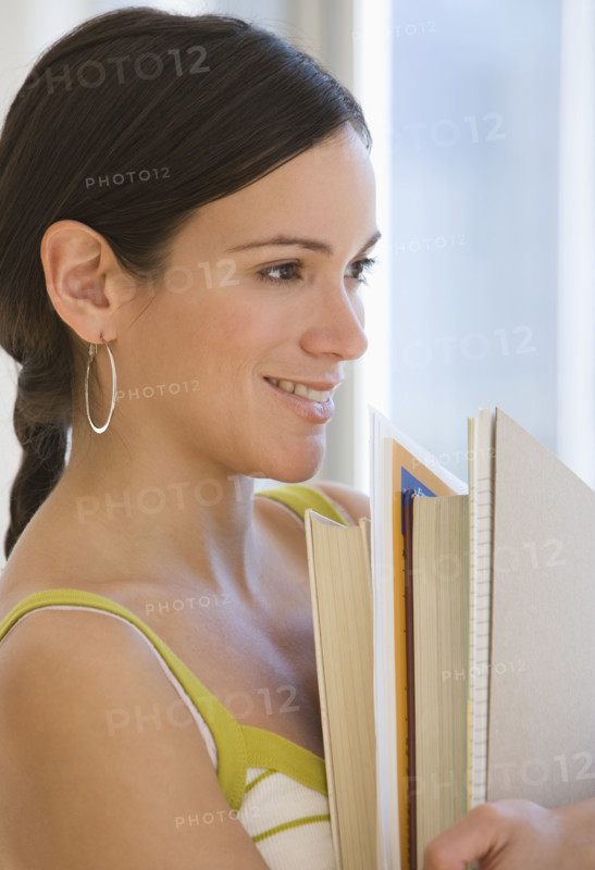Woman holding stack of school books.