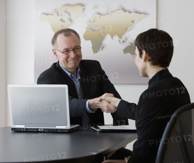Businessman and businesswoman shaking hands.