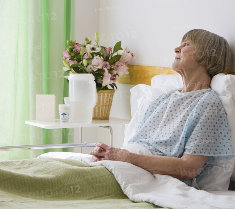 Senior woman laying in hospital bed.