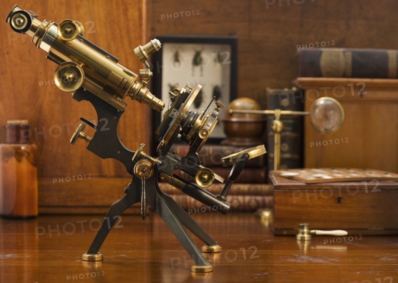 Old fashioned microscope on table.