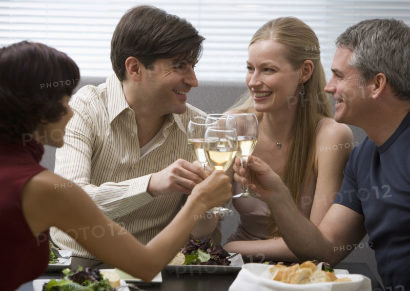 Two couples toasting at restaurant.