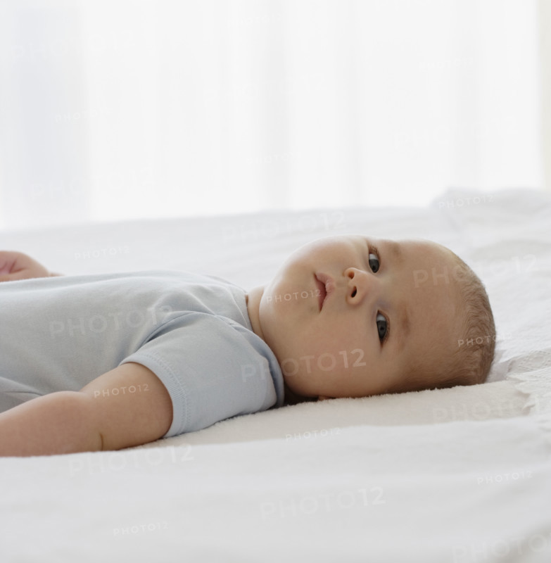 Baby laying on bed.