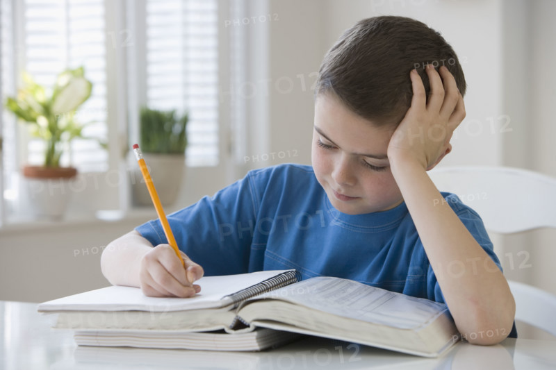 Boy doing homework at table.