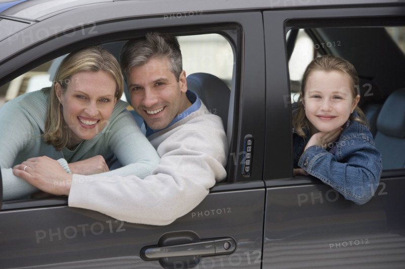 Family smiling in car.
