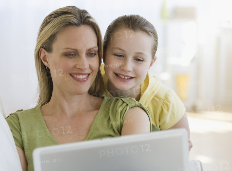 Mother and daughter looking at laptop.