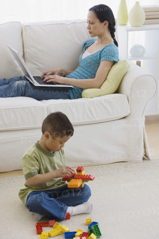 Asian mother and son relaxing in livingroom.