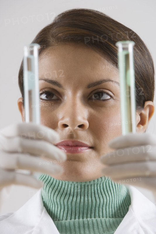 Indian female scientist looking at vials.