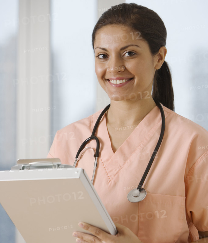 Indian female doctor writing on chart.