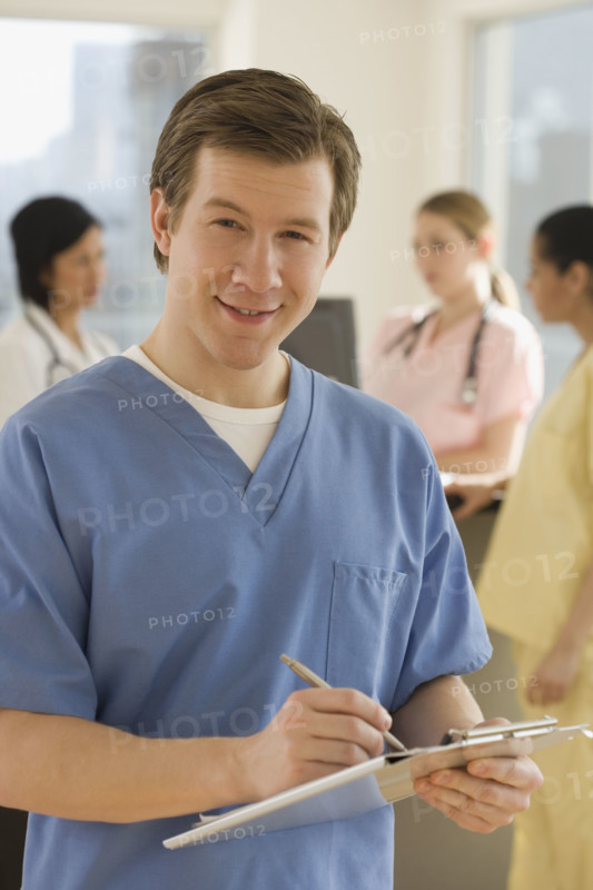 Portrait of male doctor writing on chart.