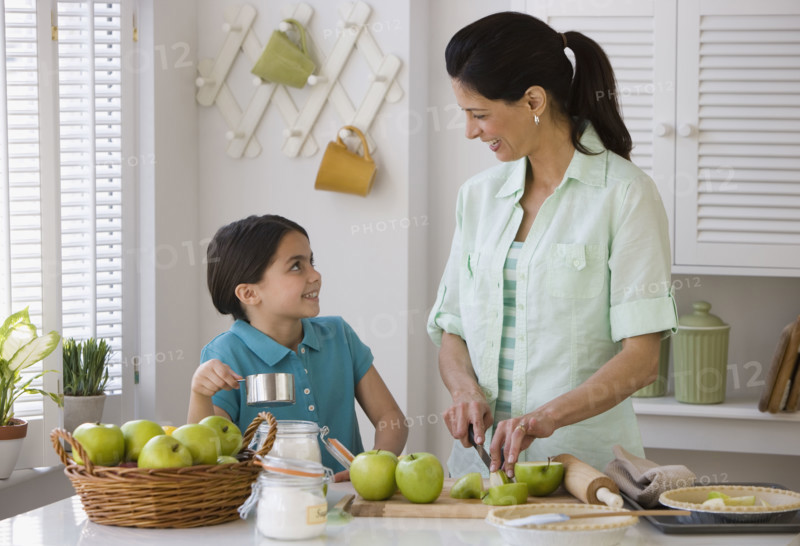 Mother and daughter making apple pie.