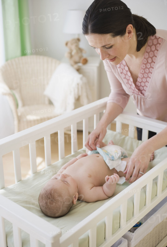 Mother changing baby’s diaper.