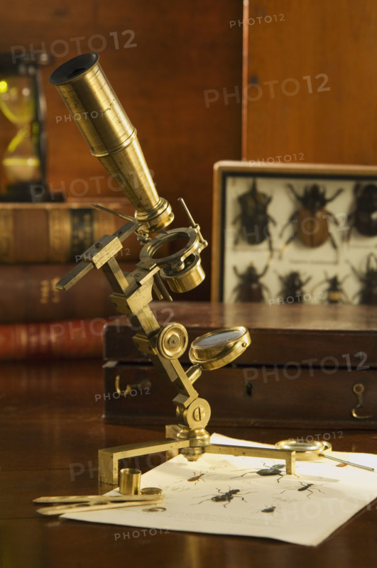 Old fashioned microscope on table.