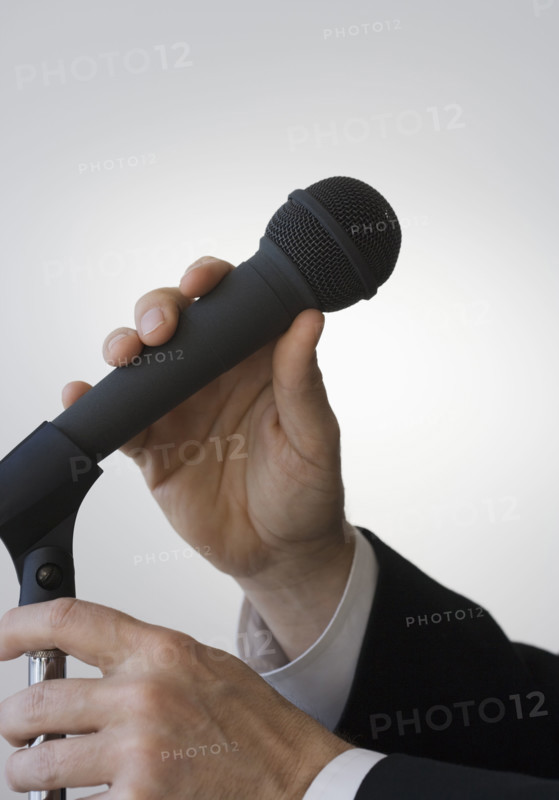 Businessman adjusting microphone.