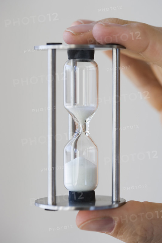 Man holding small hourglass.
