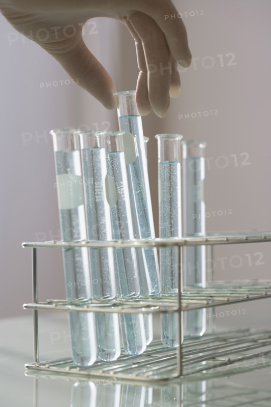 Scientist taking vial out of rack.