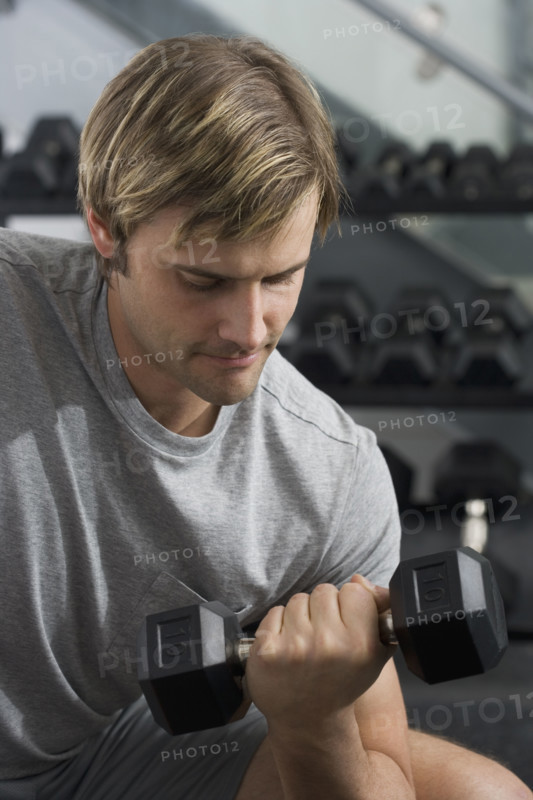 Man lifting weights at health club.