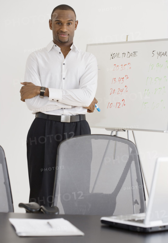 Portrait of businessman next to whiteboard.