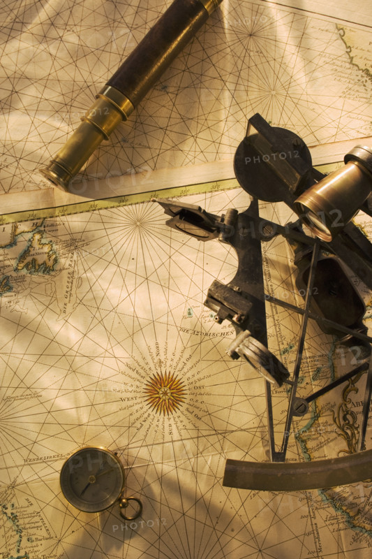 Octant, compass and telescope on nautical map.