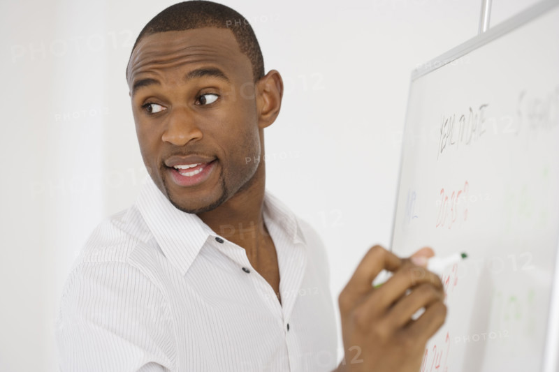 Businessman writing on whiteboard.