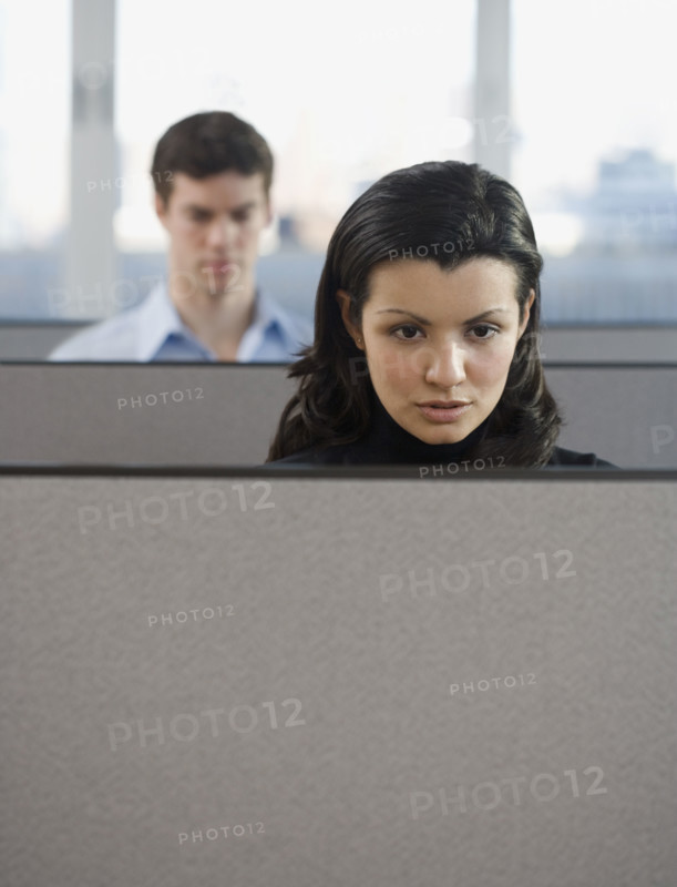 Businesspeople working in cubicles.