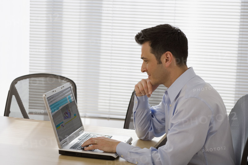 Businessman typing on laptop.