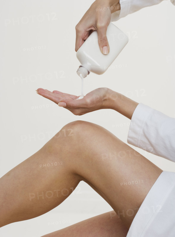Woman pouring lotion into hand.