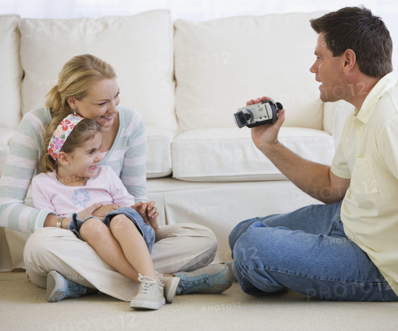 Father video recording mother and daughter.