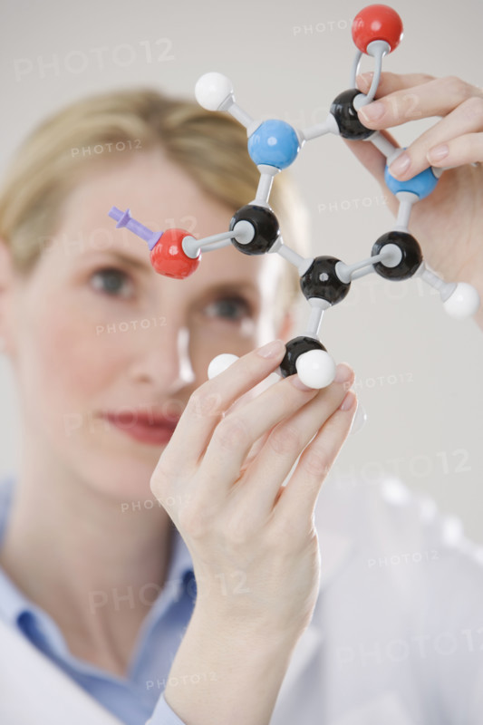 Female scientist looking at molecule model.