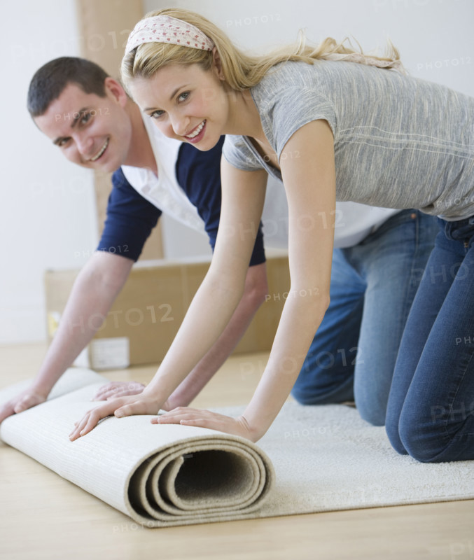 Couple unrolling rug.