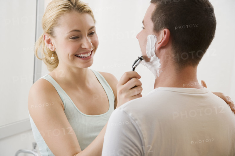 Woman shaving boyfriend’s face.