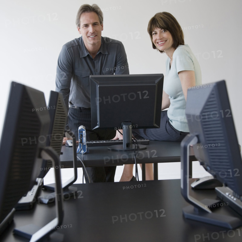 Businesspeople next to computer.