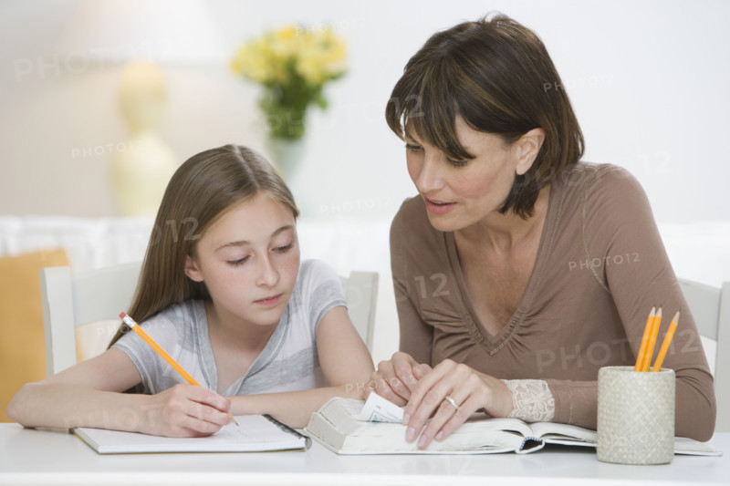 Mother helping daughter with homework.