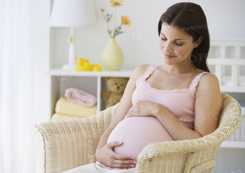 Pregnant woman with hands on belly.