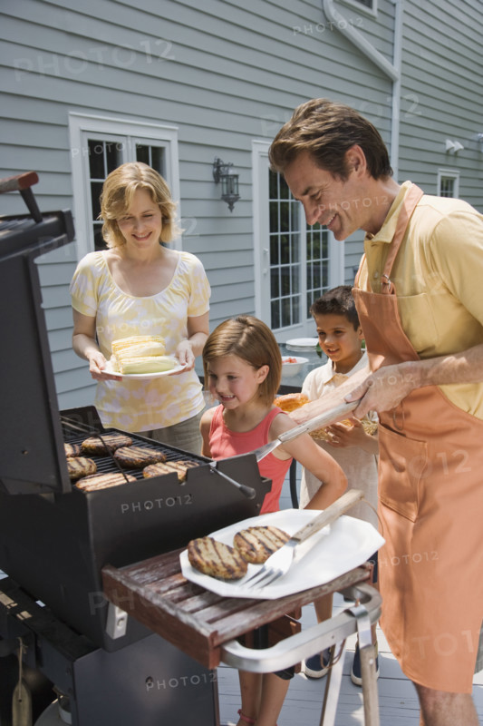 Family barbequing on deck.