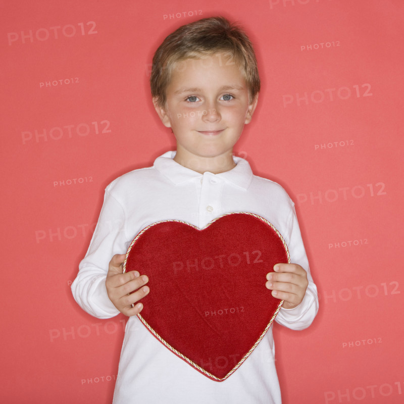 Boy holding heart-shaped box.