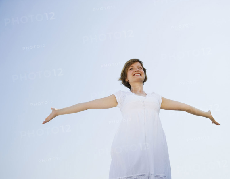 Low angle view of woman with arms outstretched.
