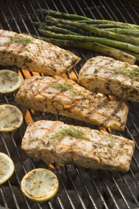 Fish and asparagus cooking on grill.