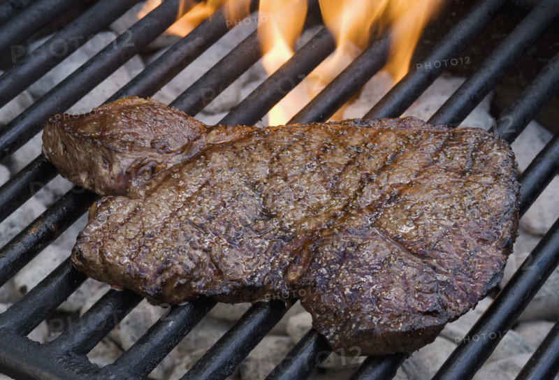 Steak cooking on grill.