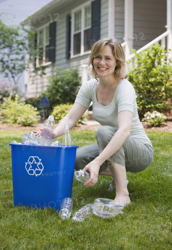 Woman filling recycling bin.