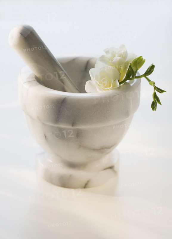 Mortar and pestle with flower.