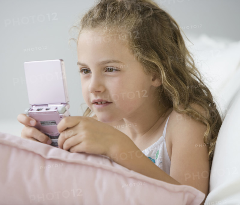 Girl playing handheld video game.