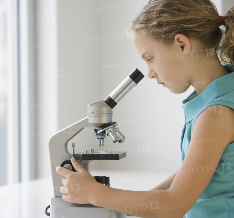 Girl looking into microscope.