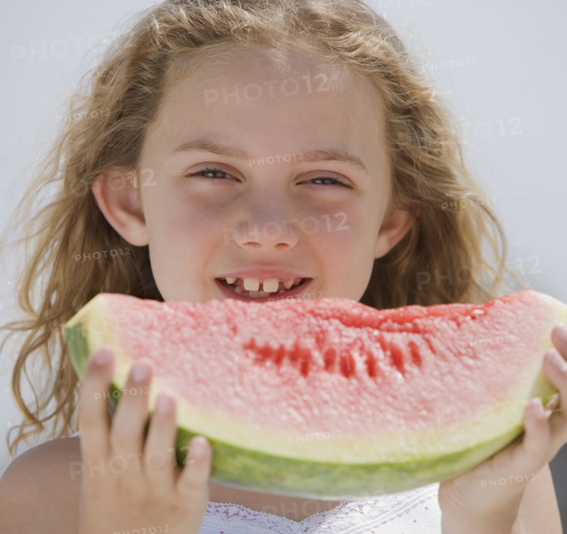 Girl eating slice of watermelon.