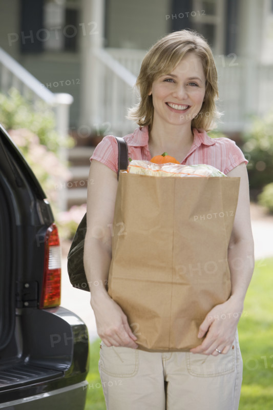 Woman holding bag of groceries.