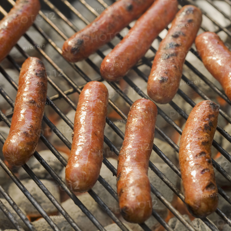 Hot dogs cooking on grill.