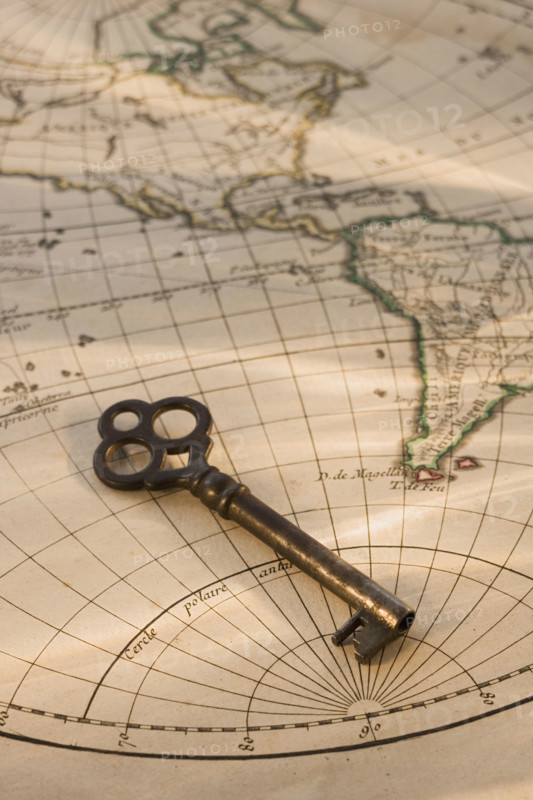 Old fashioned key on globe map.