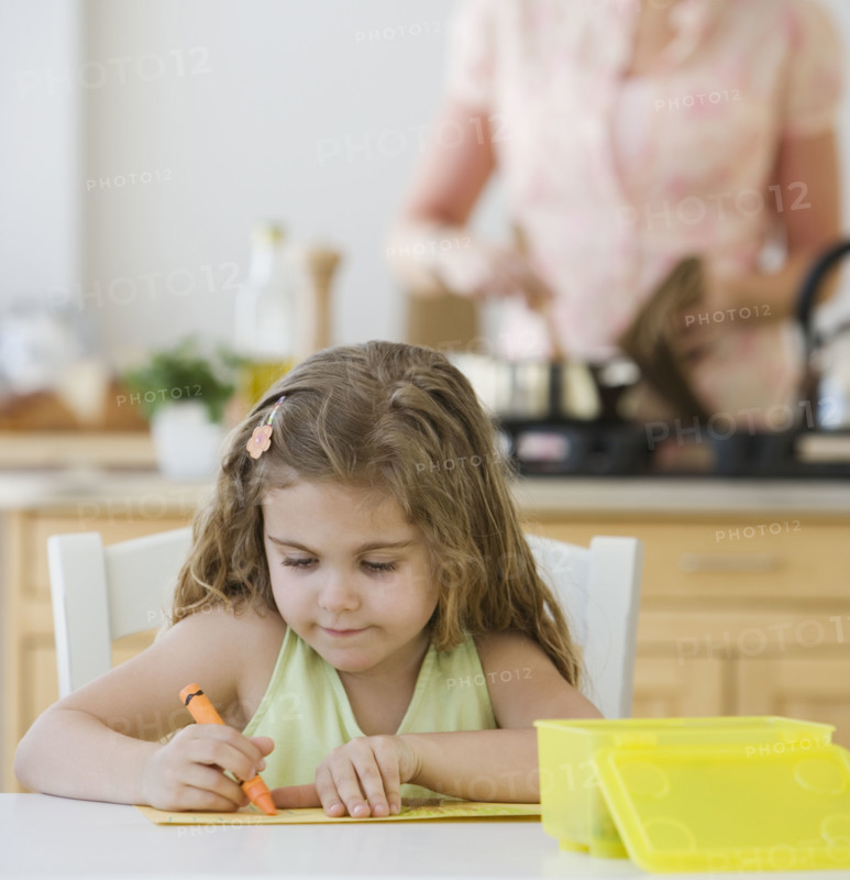 Girl coloring at kitchen table.