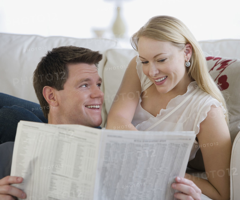 Couple reading newspaper.