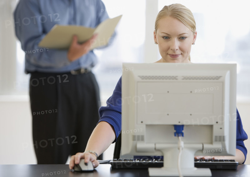 Businesswoman using computer at desk.